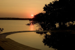 Sundowners down by the pool overlooking the lake where hippos grunt is a highly recommended activity